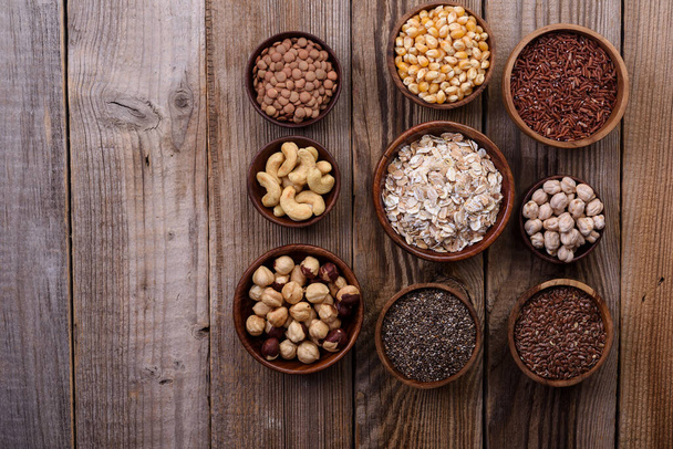 Diferentes superalimentos, semillas, nueces, granos, arándanos, avena. Concepto vegetariano de dieta saludable
. - Foto, Imagen