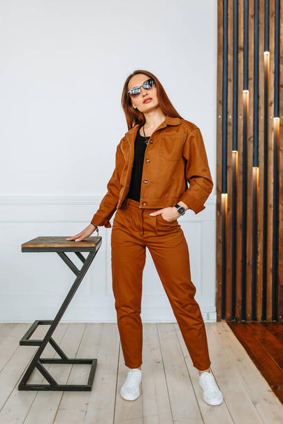 A model girl in a brown suit. Demonstration of clothing for the showroom - Foto, Imagem