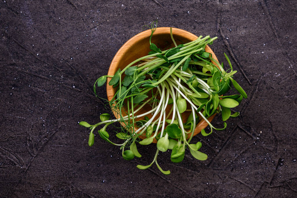 Fresh microgreens in wooden bowl.  Young plants, seedlings and sprouts. - Φωτογραφία, εικόνα