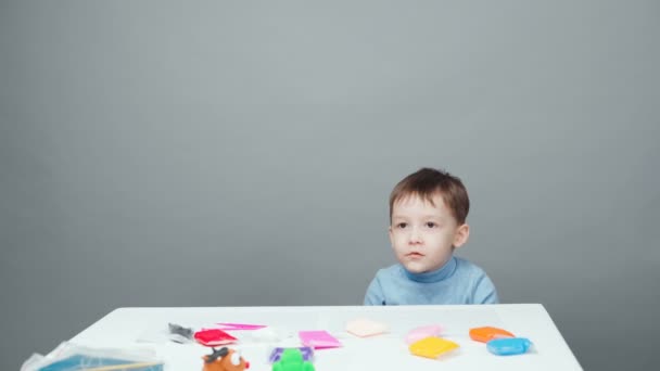 Vídeo de un niño de cuatro años esculpido en plastilina sobre fondo gris
 - Imágenes, Vídeo