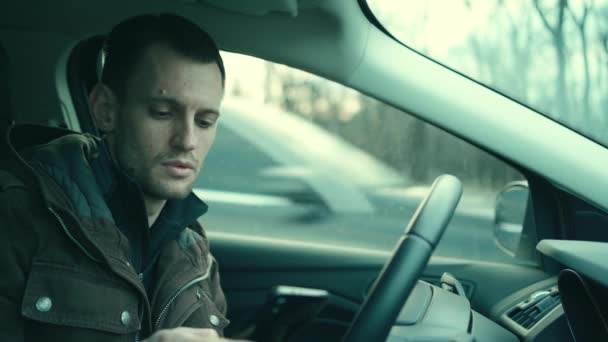 Mann fährt mit Handy in Autokabine - Filmmaterial, Video