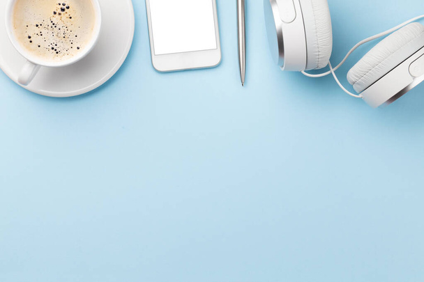 Tavolo da lavoro blu con smartphone, forniture e caffè. Vista dall'alto con spazio per il testo o l'app. Posa piatta
 - Foto, immagini