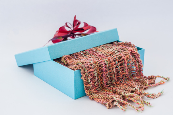Caja de regalo azul con cinta roja y bufanda a rayas en whi aislado
 - Foto, Imagen