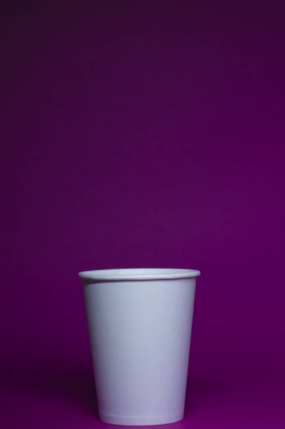 An empty white paper cup on a pink background. vertical photo.  - Photo, Image