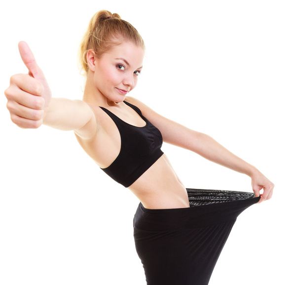 happy woman showing how much weight she lost, big pants - Foto, imagen