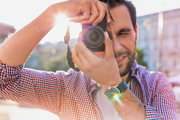 Junger attraktiver Mann hält Kamera und macht Foto - Foto, Bild