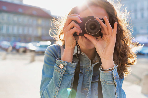 Young attractive woman holding camera and taking photo - 写真・画像