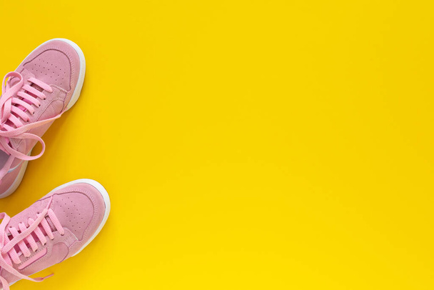 Vaaleanpunaiset lenkkarit eristetty keltaisella taustalla
 - Valokuva, kuva