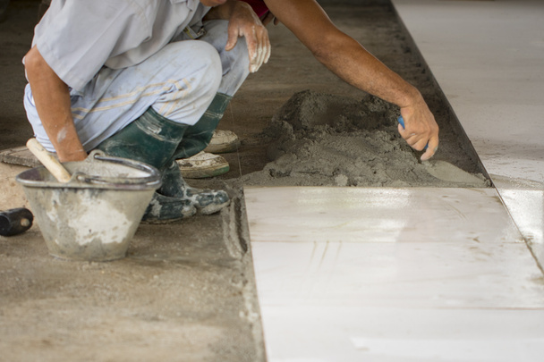 Зображення робітників мощення білої підлоги плиткою
. - Фото, зображення