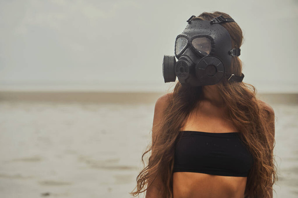 Young woman is wearing a gas mask - Fotó, kép