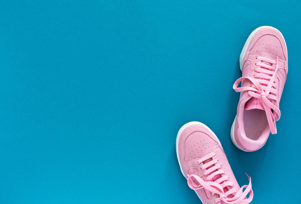Pink sneakers isolated on a turquoise blue background - Photo, Image