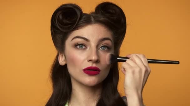 Mooie pin-up vrouw aanbrengen van make-up foundation op gezicht - Video