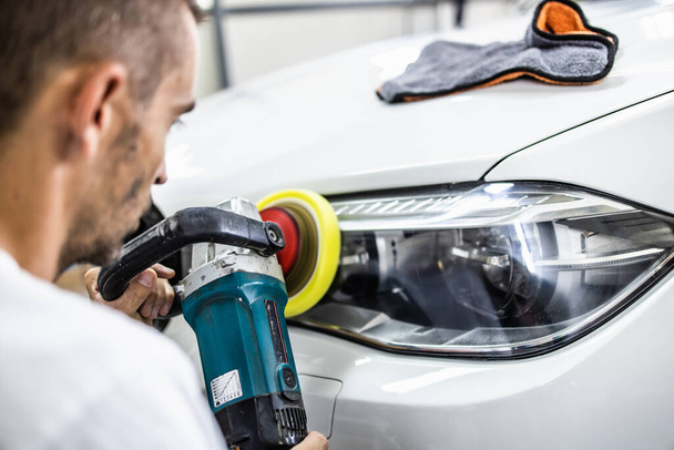 Car detailing - Hands with orbital polisher in auto repair shop. Selective focus. - Fotoğraf, Görsel