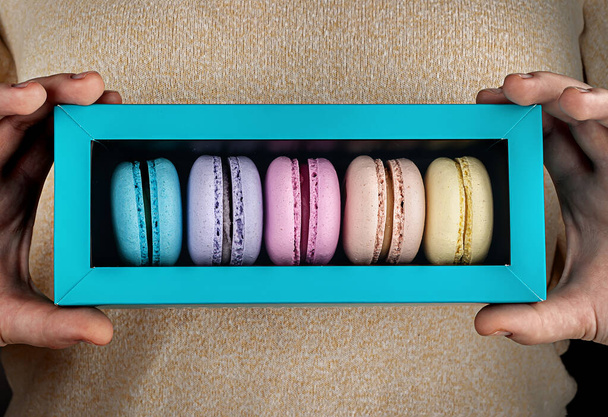 Closeup macaroons in gift box in hands - Photo, Image