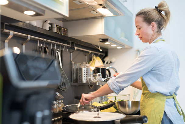 Bleiben Sie zu Hause Hausfrau Kochen in der Küche, rühren Schüssel in einem Topf, Zubereitung von Essen für die Familie Abendessen. - Foto, Bild