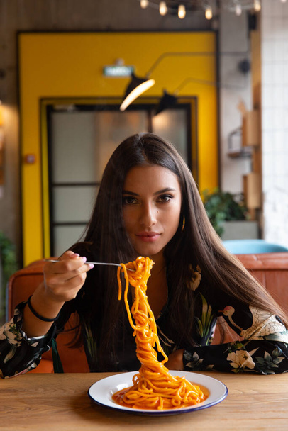 A young girl in a cafe eats pasta. selective focus - Fotó, kép