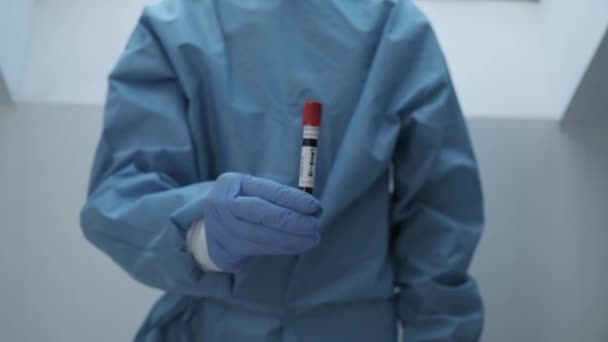 microbioloog, medisch medewerker hand in hand handschoenen met COVID-19 bloedtest resultaat - Video