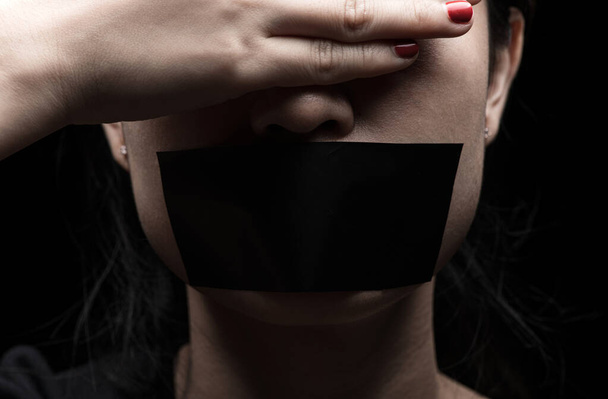Концепция на тему свободы слова, цензуры, свободы печати. Международный день прав человека: лицо девушки запечатано черной бумагой
 - Фото, изображение