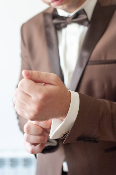 Men's hands adjust cufflinks on the sleeves. - Photo, Image