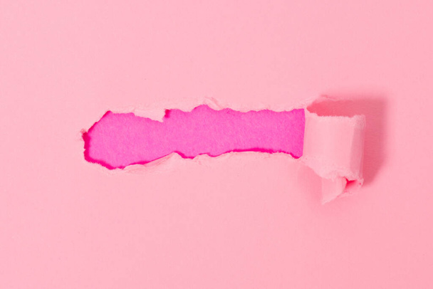 Вид зверху на рожевий рваний папір на рожевому тлі. Вільний простір для текстового банера
. - Фото, зображення