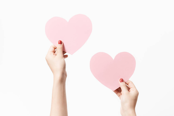 Close up women holding pink blank  paper with heart shape on white background. Free space, ready for type with text banner. Valentine's day concept - Photo, Image