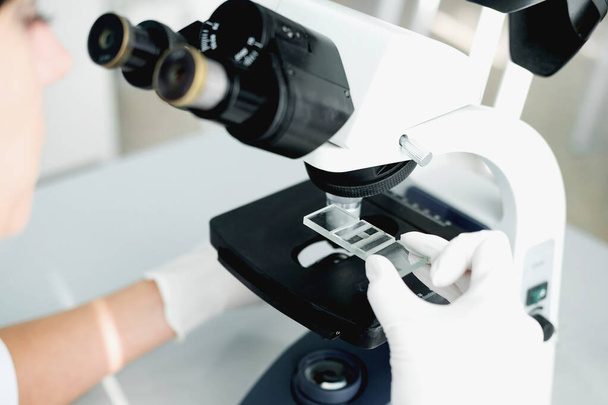 close up of scientist hands with microscope, examining samples in laboratory - Zdjęcie, obraz