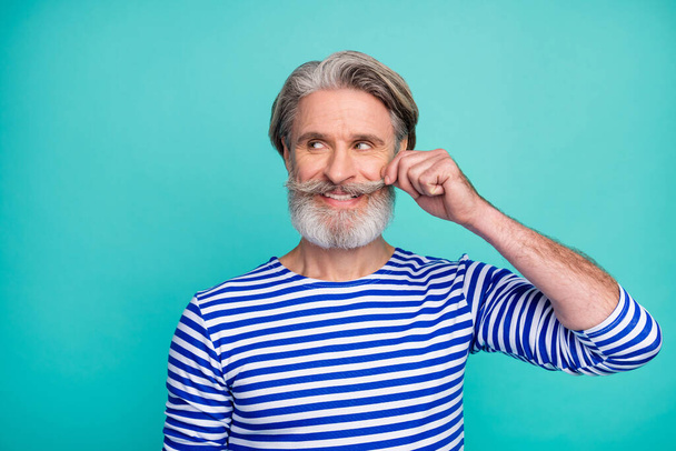 Close-up portrait of his he nice attractive cheerful grey-haired virile macho man wearing striped jumper touching mustache isolated on bright vivid shine vibrant green blue turquoise color background - Photo, image