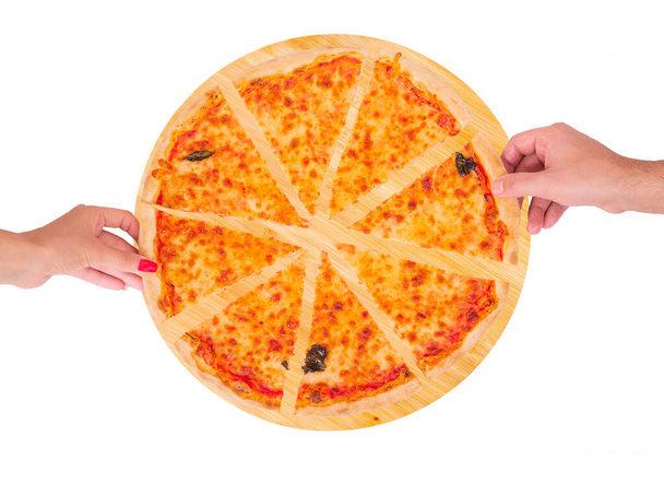 Primo piano di mani di persone che prendono fette di pizza margherita con mozzarella, bocconcini e foglie di basilico dal piatto di legno isolato su fondo bianco, vista dall'alto
 - Foto, immagini