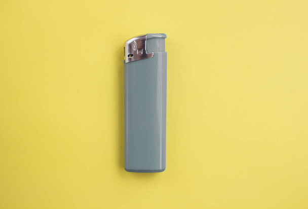  gray lighter on bright yellow and background close-up. Top view. Mock up. Flat lay composition. - Zdjęcie, obraz