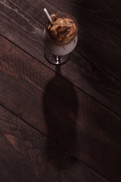 Cold trendy drink Korean dalgon iced coffee on a dark background. delicious and popular coffee in the trend - Φωτογραφία, εικόνα