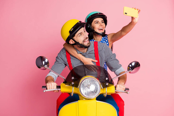 Portrait of his he her she nice attractive cheerful cheery couple driving moped taking making selfie having fun pastime summer tour isolated over pink pastel color background - Photo, Image