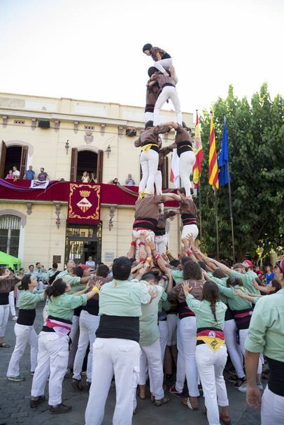 Emberekből álló csoport, akik emberi tornyot építenek. Katalónia történelmi hagyománya. A csapatmunka és a hagyományok fogalma. - Fotó, kép