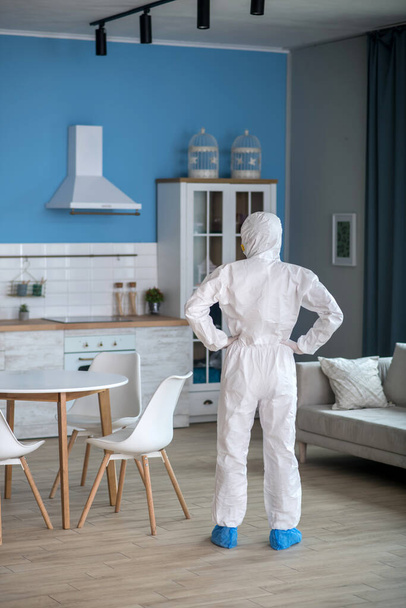 Woman in white workwear and gloves standing with hands on hips - Foto, Bild