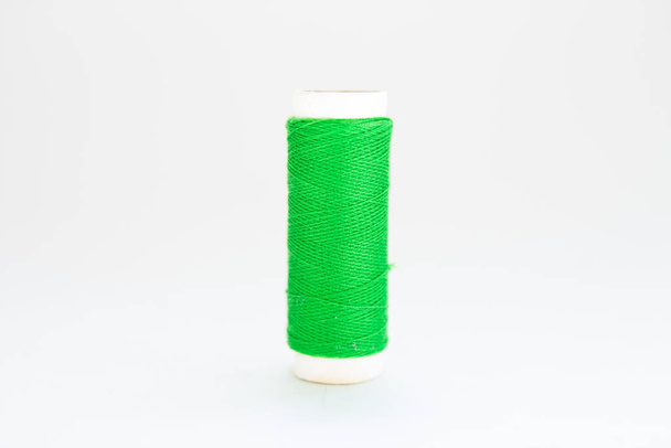 spool of green thread on a white background - Foto, immagini