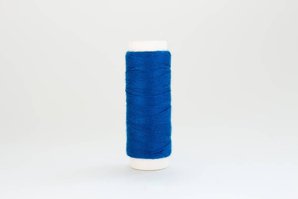 spool of blue thread on a white background - Φωτογραφία, εικόνα