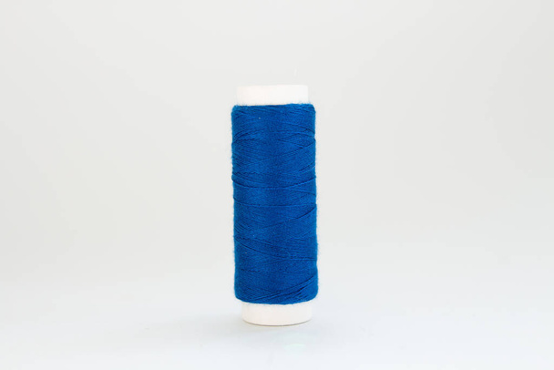 spool of blue thread on a white background - Foto, imagen