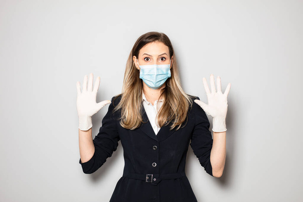 woman in office outfit wearing and showing her protection gloves and mask - 写真・画像
