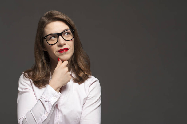 Young pensive woman with stylish glasses and red lips - Foto, Bild