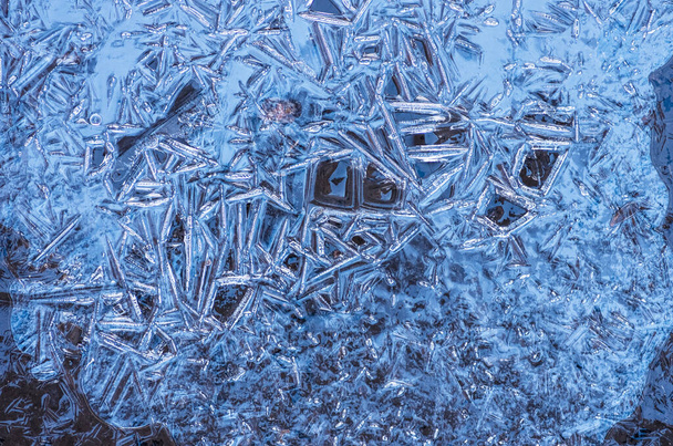 De textuur van het bevroren blauwe ijs in het meer, close-up, winterachtergrond - Foto, afbeelding