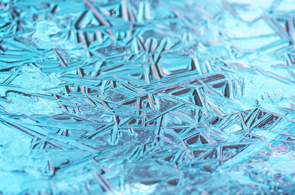 De textuur van het bevroren blauwe ijs in het meer, close-up, winterachtergrond - Foto, afbeelding