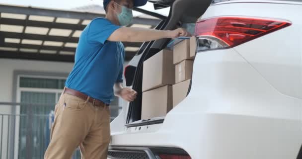Asian Delivery man wearing mask picking up the package on front receiver shipping deliver cargo social distancing, Many parcel in trunk car while the virus is spreading at sunset. - Metraje, vídeo