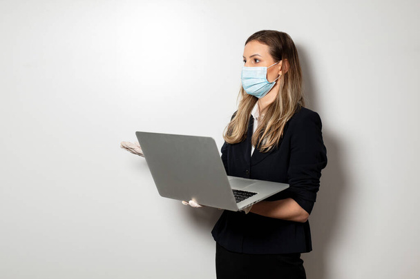 young elegant business woman wearing facial protection mask and gloves, worried not to be infected - 写真・画像