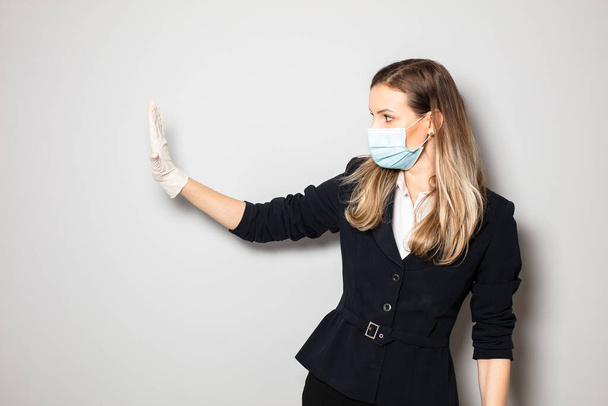 woman with mask protection and gloves pushing something or stoping the infection with virus - 写真・画像