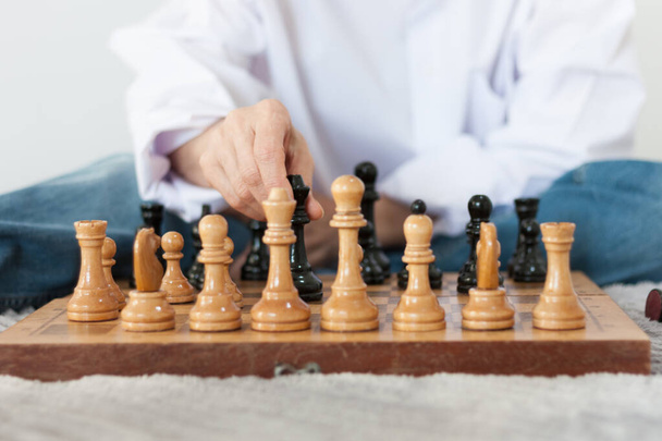 Strategy concept, hand of woman moving wooden chess figure in play, management or leadership competition business success background - Foto, Imagen