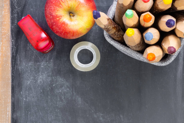 Schulstillleben mit Apfel, Buntstifte auf Kreide - Foto, Bild