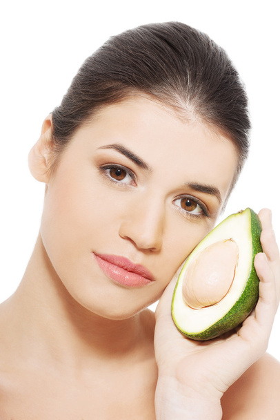 Beautiful woman's face with avocado. - Foto, imagen