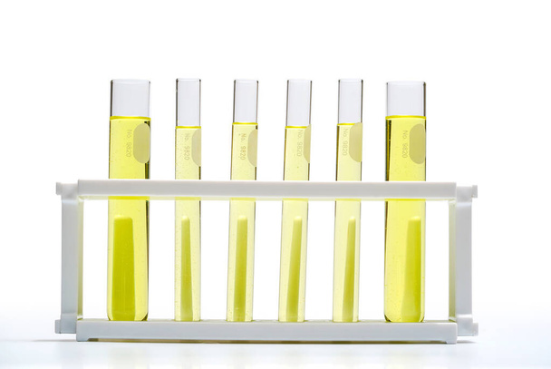 Color amarillo cosmético (aceite). Productos químicos para el cuidado de la belleza en tubo de ensayo. Níquel líquido cloruro, alcohol
 - Foto, Imagen