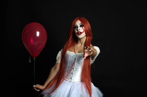 una chica en un disfraz de payaso con maquillaje aterrador
 - Foto, Imagen