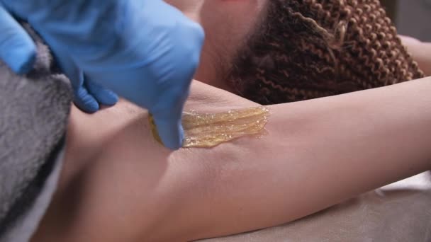 Beauty and body care concept. Sugaring: epilation with liquate sugar at armpit - Footage, Video
