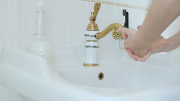 COVID-19の普及を避けるために蛇口の下の手を洗う人。2019-nCV保護 - 映像、動画